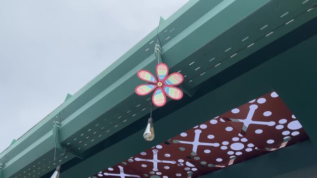 Colorful pinwheel spinning in the wind under sunlight, capturing playful motion, cheerful outdoor atmosphere, and dynamic movement in a bright natural setting.