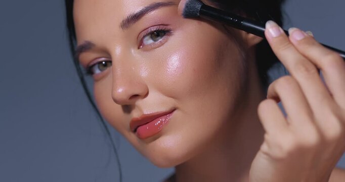 Makeup Close-Up Woman Applying Eyeshadow with Brush in Studio