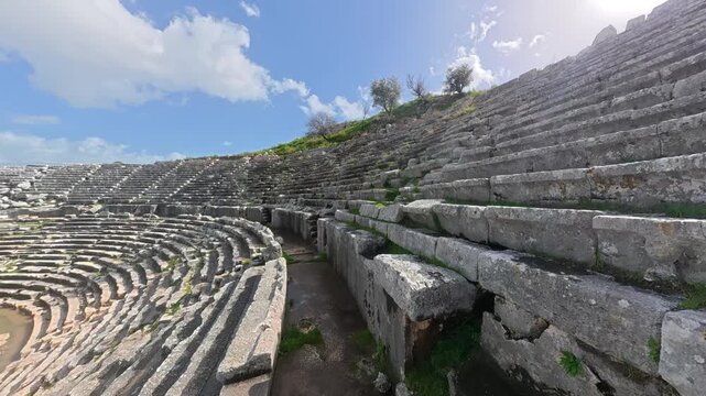Ancient stone seating of the Hellenistic theater at Letoon ancient city, showing curved rows, weathered textures and terraced structure near city of Xanthos, Mugla, Turkey