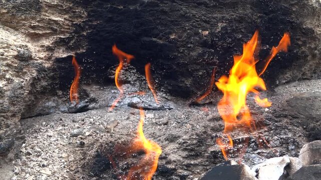 Yanartas methane flames burn through rocky vents at Cirali Antalya Turkey as eternal fire. Natural gas seepage creates a geological phenomenon with burning stone, fumarole heat, scientific interest.