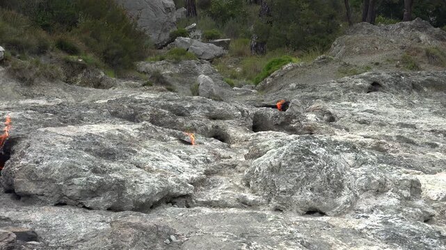 Yanartas methane flames burn through rocky vents at Cirali Antalya Turkey as eternal fire. Natural gas seepage creates a geological phenomenon with burning stone, fumarole heat, scientific interest.