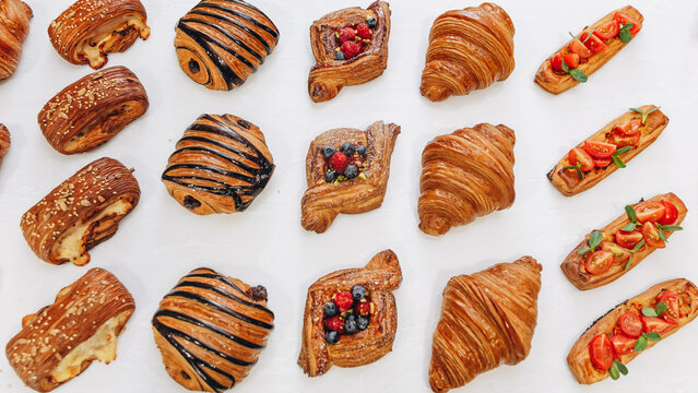 Assorted bakery pastries and croissants arranged on a white table for breakfast and brunch