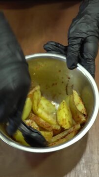 Professional Chef Seasoning Fresh Raw Potato Wedges with Spices