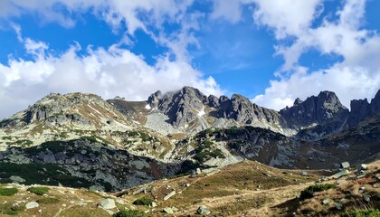 Fototapeta premium Majestic Mountain Range Under a Cloudy Blue Sky.