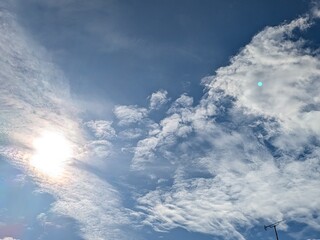 Obraz premium Beautiful blue summer air with fluffy white clouds and chem trail lines across the sky