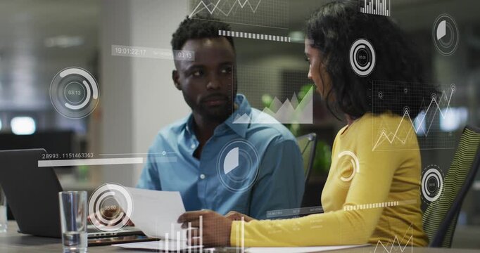 Animation of data processing against diverse man and woman discussing over a document at office