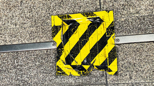 Yellow and Black Caution Tape Marking on Concrete Surface