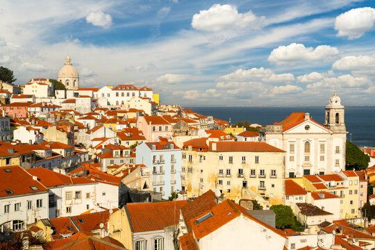 Alfama Oldest Historic Neighborhood on Sunny Day. Red Roofs and White Houses. Vibrant Lisbon Old Town, Portugal. View from Miradouro das Portas do Sol