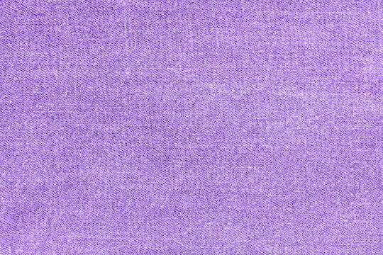 Macro top view photography of purple denim. Stone washed cloth jeans texture. Full depth of field