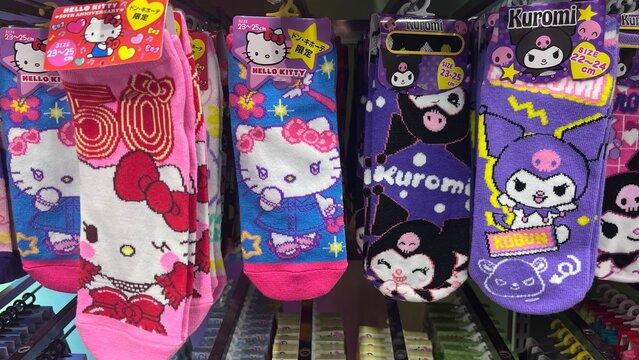Selection of Sanrio character socks featuring Hello Kitty 50th Anniversary and Kuromi designs, available at Don Quijote department store - Japan, August 27, 2025