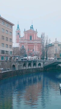 Snowing in Ljubljana city center on Presernov trg view over Ljubljanica river