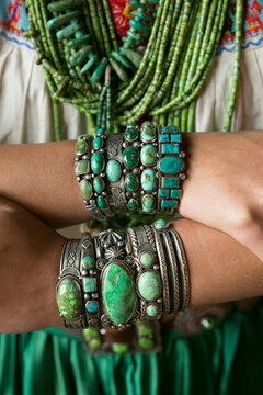 Stacked turquoise bracelets and silver jewelry on forearms