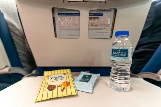 Bottled water, cookies, and peanuts on seat tray on Malaysia Airlines Boeing 737