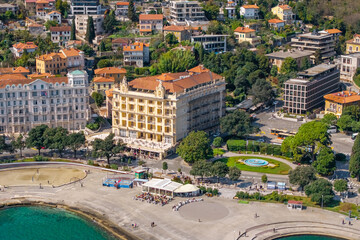 Fototapeta premium Aerial coastal view of Opatija waterfront with grand historic hotels, promenade, small beach area and urban square with fountain