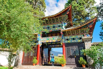 Intricate colorful traditional temple entrance patterns in Baisha Village. Detailed geometric, floral and fauna motifs highlighting ancient architecture.