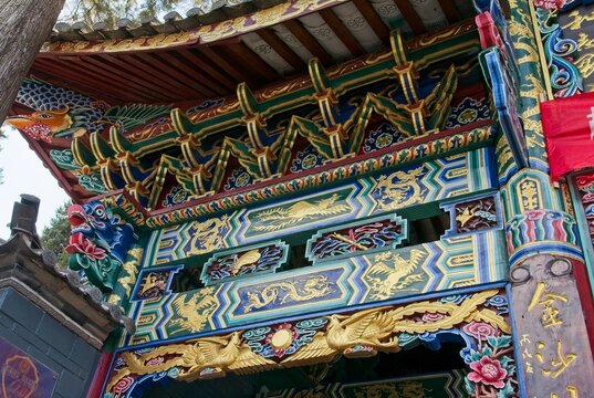 Intricate colorful traditional temple entrance patterns in Baisha Village. Detailed geometric, floral and fauna motifs highlighting ancient architecture.