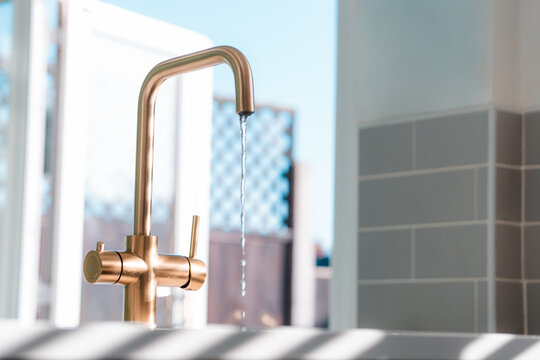 Gold kitchen tap faucet and sink, clean home interior