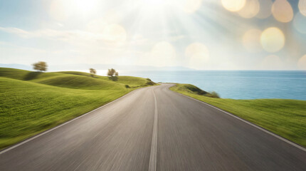 Fototapeta premium A dynamic, motion-blurred photograph from a low perspective, capturing a car's rapid journey along a winding coastal highway. Sunlight flares, bokeh, and green hills against a blue ocean background.