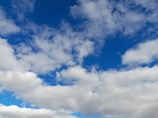Obraz premium Beautiful bright blue sky with fluffy white cumulus clouds on a sunny day