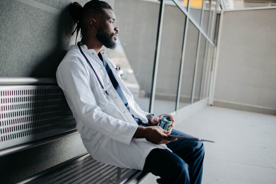 Tired medical worker sitting in front of the hospital