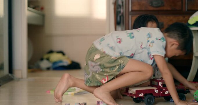 Little asian kids boy and girl enjoy play toy car fix repair in cozy room kids education
