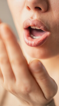 Woman is checking smell of breath