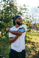 Fototapeta premium Smiling Black male runner checking smartwatch