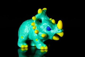 Toy Dinosaur Chasmosaurus on a black glass background © nedomacki