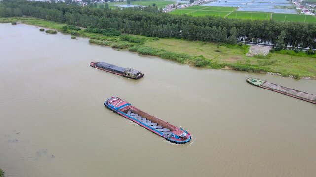 Aerial view of cargo barges on a canal beside farmland in rural China