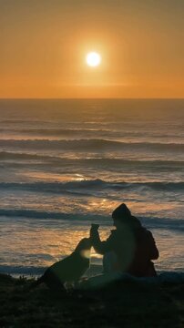 Man and dog playing on ocean at sunset
Joyful lifestyle moment of man and dog running and playing on beach with waves and golden sunset.