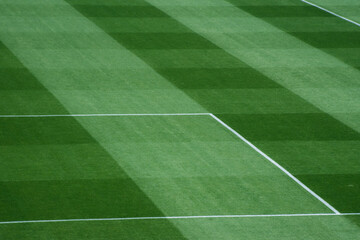 Fototapeta premium Background Texture of International-Standard Football Pitch with Striped Grass and Field Lines Under Clear Conditions