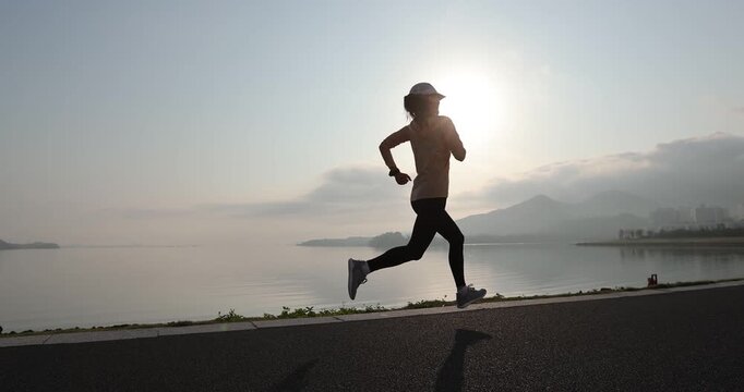 Fitness woman runner running at seaside
