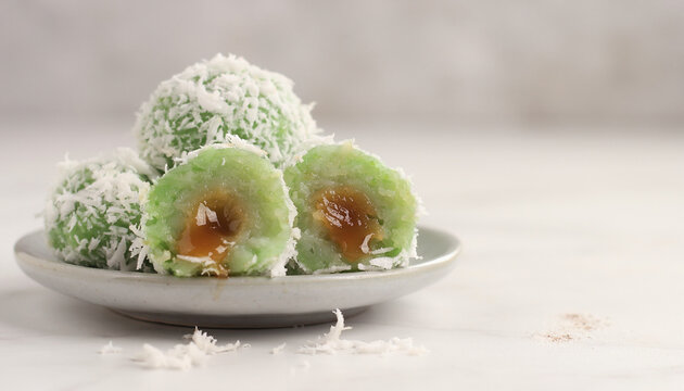 realistic photo of klepon covered with grated coconut, green color, cut open showing