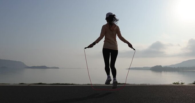 Fitness woman rope skipping  at seaside