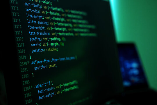 Focusing on a screen filled with CSS code lines. Dark background contrasts with bright green text. Each line details style attributes for web design.