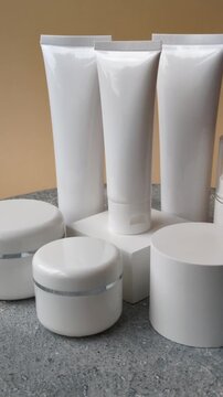 A set of empty white plastic or aluminum jars, tubes, and sprays as mockup. Empty cosmetic jar and tube mockups as background for your design