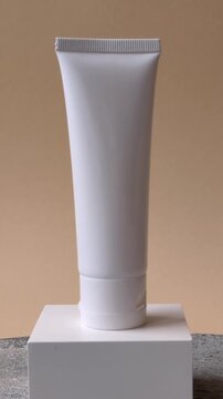 A white empty plastic or aluminum tube for cream, paste, gel, or shampoo as a mockup. An empty cosmetic tube mockup as a background for your design