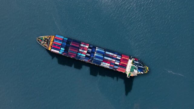 Container ship navigating global trade routes with shipping containers stacked high amidst logistics challenges