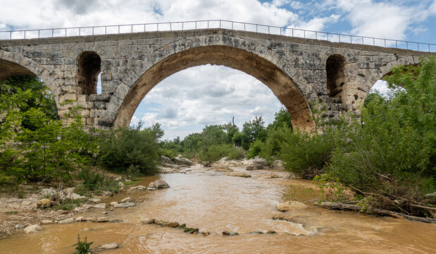 Pont Julien Ancient Roman Bridge from 3BC, across the Calavon River, Bonnieux, Vaucluse, Provence, France.  With Openings for Floodwaters to Flow Through the Bridge