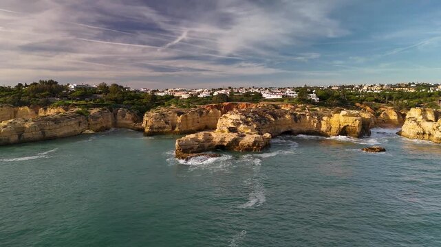 Sunset Aerial View Circling Coastal Cliffs and Caves at Praia dos Paradinha Albufeira Portugal