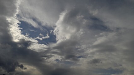 Obraz premium Dramatic sky with dark storm clouds and bright sunlight breaking through.