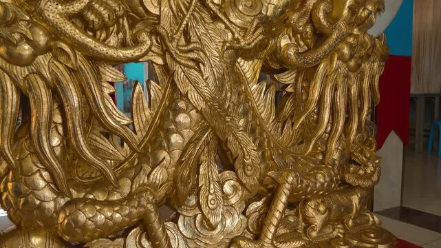 A massive highly detailed ornate golden statue of a phoenix located in Saigon Cao Dai Temple in Ho Chi Minh City, Vietnam