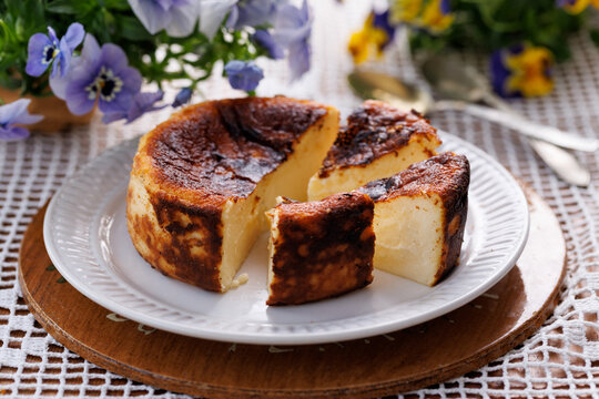 Basque cheesecake portioned on a white plate, close-up view