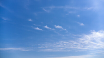 Naklejka premium Clear Blue Sky with Scattered White Clouds