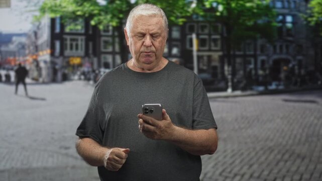 Man holding smartphone tapping screen on a city street, hands visible and intent on device; concentration connection.
