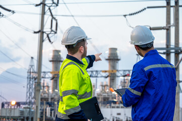 Engineers Monitoring Electrical Equipment at Power Station Site © SAHARAT