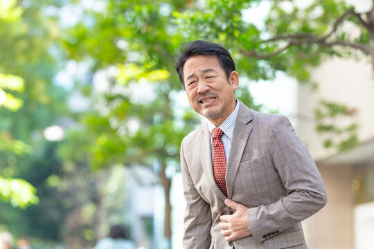 腹痛をもよおすミドル男性ビジネスマン