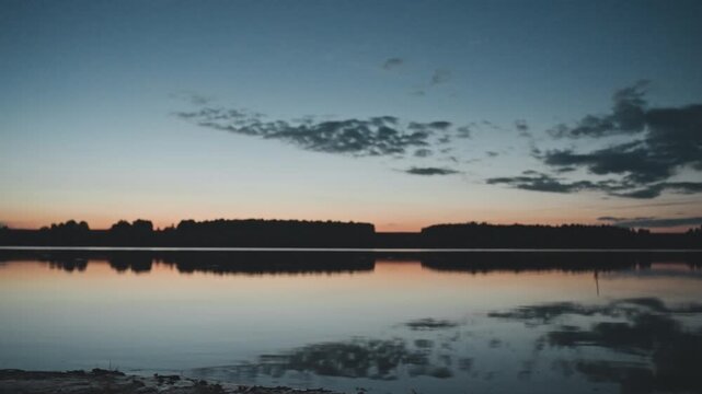 Wide calm lake reflection at sunset, mirrorlike water and low treeline silhouette across horizon soft pastel sky with scattered clouds, peaceful evening atmosphere, ideal background for travel