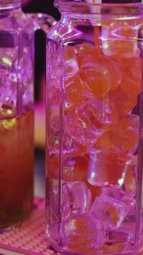 Barman mixing and pouring drinks and beverages, beautiful row line of different coloured lemonades in a jar, liquor alcohol cocktails on a party in bar, catering banquet on event, mocktails in a jug 