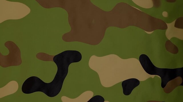 Panning shot of camouflage fabric pattern sliding across textured textile backdrop for military clothing closeup in studio interior